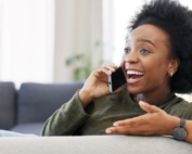 Excited young woman talking on the phone.