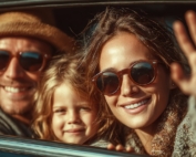 A young family in a car waving goodbye.