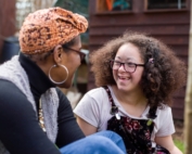Mother and daughter sitting and talking together and laughing.