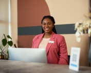 Friendly black receptionist is welcoming people to the office.