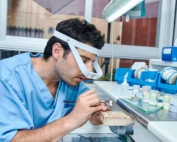 Dental technician working on a set of teeth in a dental lab.